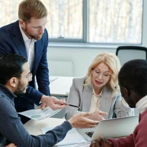 Consultor explicando estrategia a clientes frente a una pantalla con gráficos